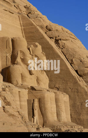 Ägyptische Kunst Großen Tempel von Ramses II. Zwei kolossale Statuen, die den Pharao Ramses II (1290-1224 v. Chr.) Mit dem nemes Kopf sitzt und durch die doppelte Krone überragt. 19. Dynastie. Neuen Reich. Abu Simbel. Ägypten. Stockfoto