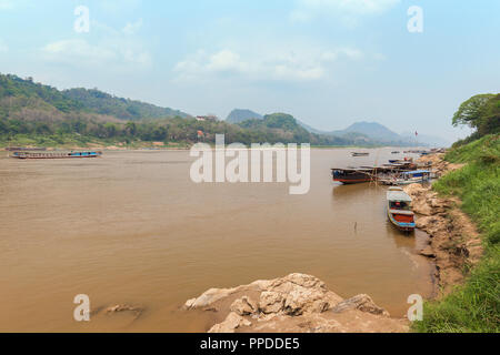 Blick auf wenige Boote auf dem Mekong und Chomphet Bezirk über den Fluss in Luang Prabang, Laos, an einem sonnigen Tag. Stockfoto