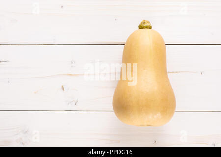 Eine ganze glatte Birnenförmig orange Kürbis waltham Vielzahl flatlay auf weißem Holz Stockfoto