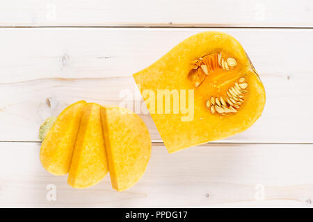 Gruppe von einem Quartal drei Scheiben glatte Birnenförmig orange Kürbis waltham Vielzahl flatlay auf weißem Holz Stockfoto