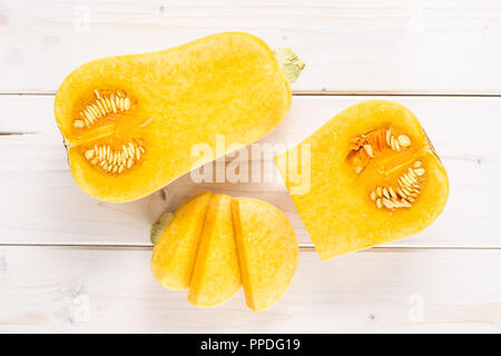 Gruppe von Hälfte ein Viertel drei Scheiben glatte Birnenförmig orange Kürbis waltham Vielzahl flatlay auf weißem Holz Stockfoto