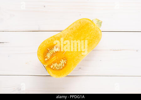 Die eine Hälfte der glatten Birnenförmig orange Kürbis waltham Vielzahl flatlay auf weißem Holz Stockfoto
