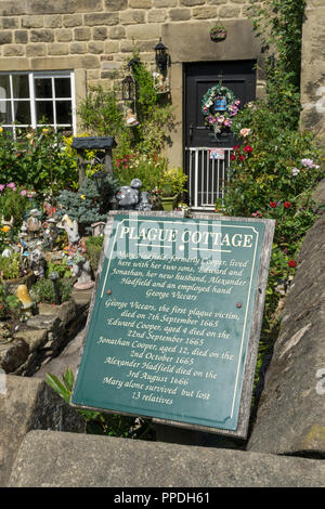 Information Board vor einem bunten Bauerngarten im Sommer in einem der so genannten Pest Cottages, Eyam, Derbyshire, Großbritannien Stockfoto