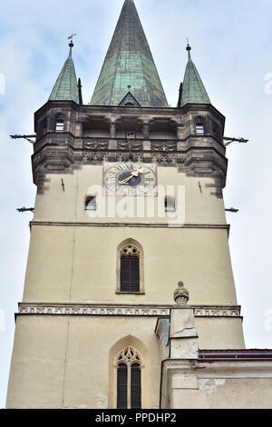Glockenturm der gotischen Kathedrale des Heiligen Nikolaus in Presov mit Bogenfenstern und Veranda unter spitzem Dach. Uhr am Glockenturm Wand verwendet Lateinische Ziffern. Stockfoto