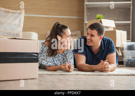Paare, die sich in Haus sitzen auf dem Boden. Freundliche junge Paar Stockfoto
