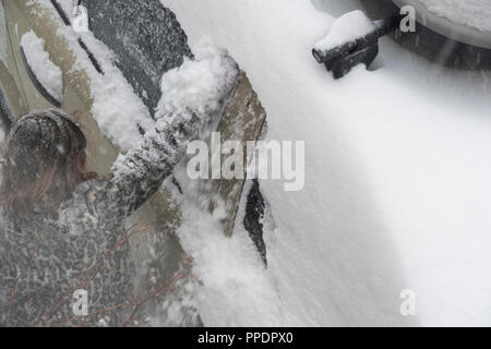 Sheffield, Großbritannien - 28 Feb 2018: Spielen im Schnee: Mädchen schabt Schnee aus ein Auto, da das Tier aus dem Osten griffe Sheffield in eisige Winter Wetter Stockfoto