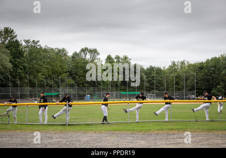 Teenage Baseball spieler ausdehnen, bevor ein Ball Spiel Stockfoto