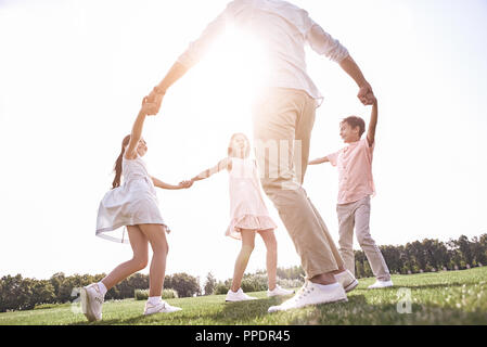 Kleben. Familie von vier Hände halten tanzen im Kreis auf einem gra Stockfoto