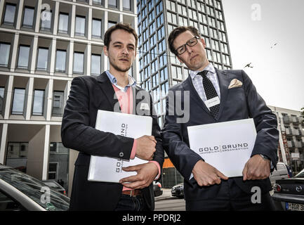 Satirische vertrieb Tour des (fiktiven) Goldgrund Immobilien Organisation um die Objekte der Betrachtung der Stadt München. Im Bild das Immobilienmakler 'Dvon Stahlnik' und 'Mark Sitzbank irk' am Start in der Muellerstrasse 6 in der Isarvorstadt, wo der Luxus Projekt "Die Sieben" befindet. Stockfoto