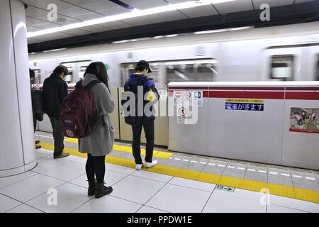 Tokio, Japan - Dezember 2, 2016: Leute für Zug der Toei U-Bahn in Tokio warten. Toei U-Bahn und Tokyo Metro sind 285 Stationen und haben 8,7 Millionen dai Stockfoto