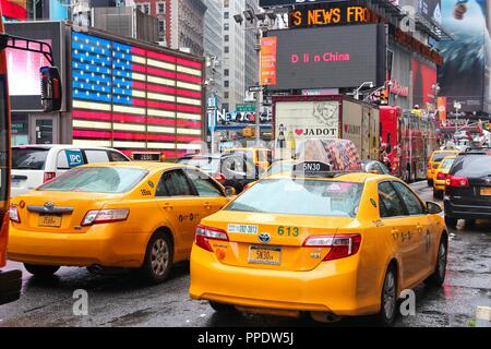 NEW YORK, USA - 10. JUNI 2013: Taxis fahren am Times Square in New York. Der Times Square ist eine der bekanntesten Sehenswürdigkeiten der Welt. Mehr als 300,0 Stockfoto