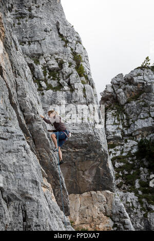 Cortina d'Ampezzo, Italien - 17. August 2018: ein Bergsteiger klettert mit seinen Händen, die auf einer felsigen Wand. Lage Cinque Torri, Dolomiten. Stockfoto