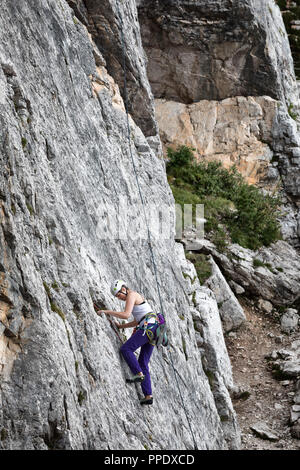 Cortina d'Ampezzo, Italien - 17. August 2018: ein Bergsteiger klettert mit seinen Händen, die auf einer felsigen Wand. Lage Cinque Torri, Dolomiten. Stockfoto