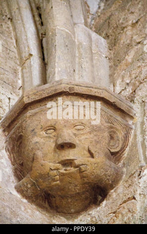 Lustige mittelalterliche Skulptur eines Kopf mit zwei Fingern im Mund, die Spalte in der Kathedrale von saint-fulcran in Lodeve, Frankreich Stockfoto