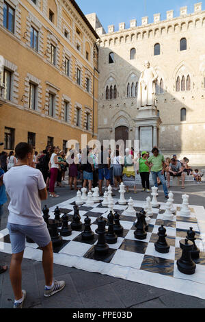 Menschen spielen im Außenbereich Riesenschach, Piazza Salimbeni, Siena, Toskana Italien Europa Stockfoto