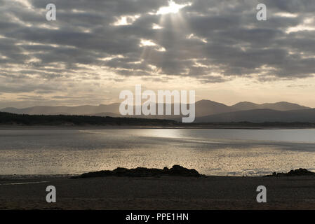 Blick von llanddwyn Island (ynys Llanddwynn), Anglesey, Nordwales, über den Strand bei Ebbe zu Snowdonia Mountains im Morgenlicht Stockfoto