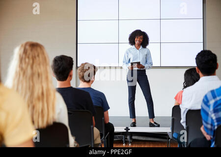 Lehrerin mit digitalen Tablet eine Präsentation halten zu High School Klasse Vor der Bildfläche Stockfoto