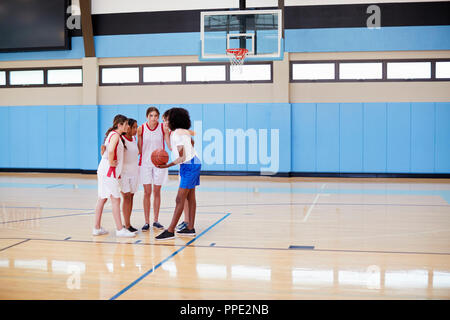 Weibliche High School Basketball Spieler in Unordnung in Team sprechen mit Trainer Stockfoto