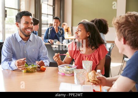 Lehrer und Schüler das Mittagessen in der High School Cafeteria während der Aussparung Stockfoto