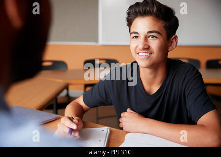 High School Tutor Die männlichen Kursteilnehmer Einzelunterricht am Schreibtisch Stockfoto