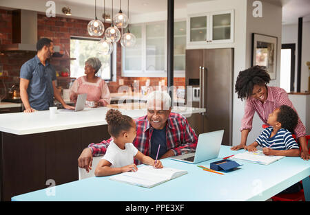 Kinder Hausaufgaben in geschäftigen Multi Generation Familie Home Stockfoto