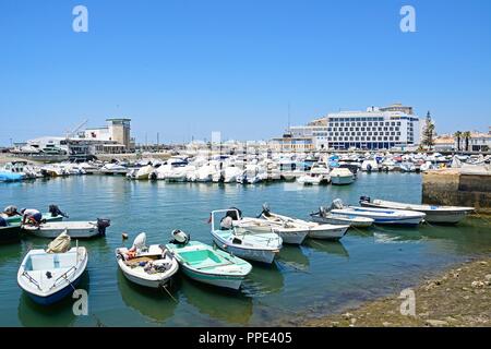 Kleiner Motor Yachten in der Marina mit einer Waterfront Hotel an der Rückseite, Faro, Algarve, Portugal, Europa günstig. Stockfoto