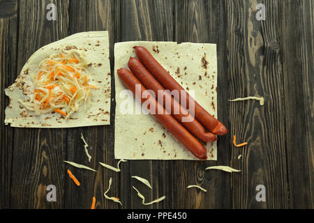 Wurst und Kohl auf pita Brot isoliert auf Holz geräuchert zurück Stockfoto