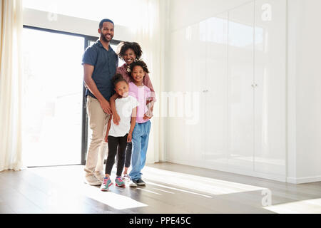 Portrait von Angeregten Familie im leeren Raum der Neuen Heimat stehen auf beweglicher Tag Stockfoto