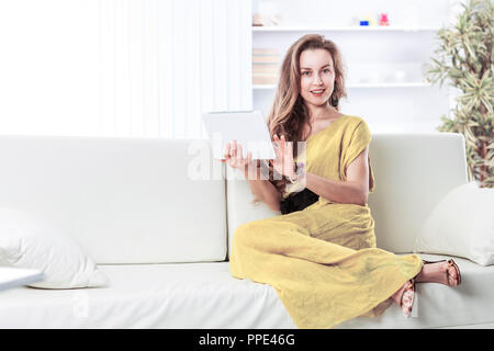 Business Frau mit Tablet-PC auf dem Sofa sitzen in der Baumschule Stockfoto