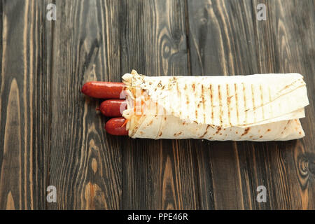 Hausgemachte Wurst in pita Brot auf hölzernen Hintergrund. Foto mit Stockfoto