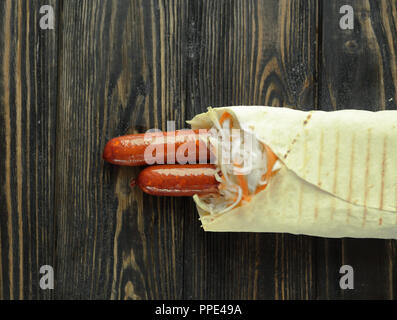 Ausschreibung Wurst in pita Brot auf hölzernen Hintergrund. Foto mit Co Stockfoto