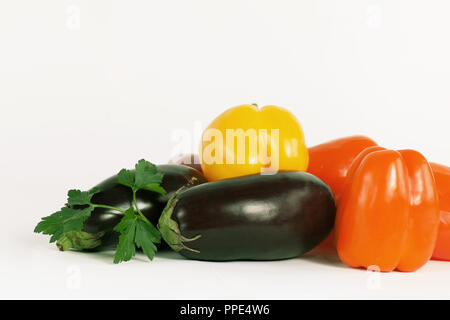 Paprika, Auberginen und Zweige Petersilie auf einem weißen backgroun Stockfoto