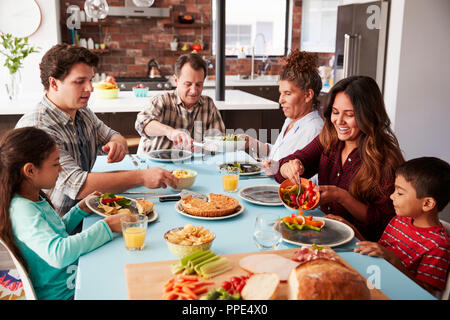 Multi-Generation Familie Mahlzeit um Tisch zu Hause zusammen Stockfoto