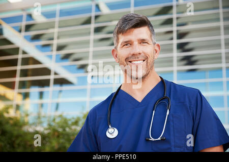 Lächelnd männlichen healthcare Arbeiter außerhalb des Spitals, Porträt Stockfoto