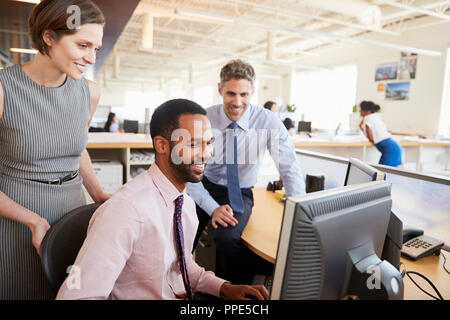 Drei glückliche Kollegen auf einen Computerbildschirm zusammen Stockfoto