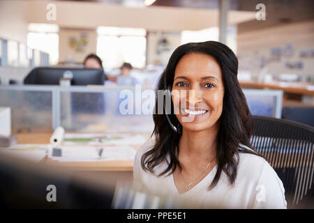 Junge gemischte Rasse Frau in einem Call Center zu Kamera suchen Stockfoto