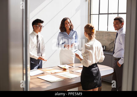 Vier Kollegen gemeinsam in einem kleinen Büro Stockfoto