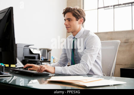 Jungen weißen Geschäftsmann mit einem Computer im Büro Stockfoto