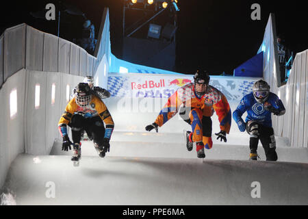 Bei der Red Bull Crashed Ice Wettbewerb im Münchner Olympiapark Teilnehmer Rennen auf der ICE-Strecke auf dem Olympiaberg. Stockfoto