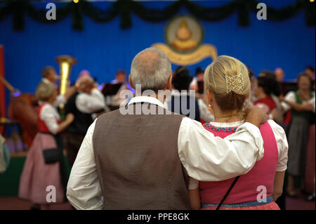 Ein älteres Paar lauschen Sie dem Konzert 'Die Hoerbacher Rassoraeuber treffen das Hattenhofer Blech" in der "Herzkasperl" Festival Zelt auf der Wiesn Oidn (Alte Wiesn). Stockfoto