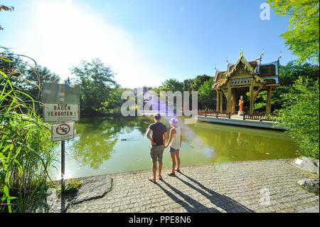 Ein paar Blicke auf den See in Richtung Westpark Thai-Sala. Neben ihnen das Zeichen "Baden verboten". Stockfoto
