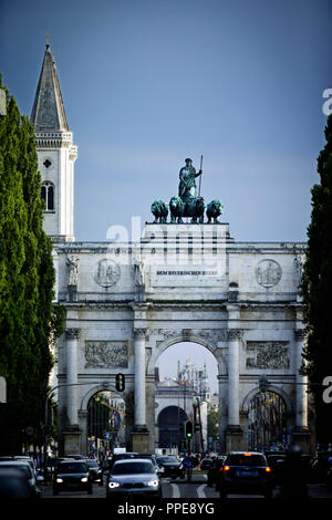 Das siegestor (Sieg Tor) und einen Turm der Ludwigskirche (katholische Pfarr- und Universitätskirche St. Louis) in der Maxvorstadt in München, von der Leopoldstrasse gesehen. Stockfoto