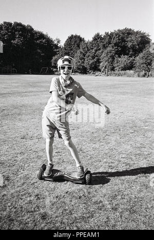 9 Jahre alter Junge, ein Hoverboard, Medstead Park, Hampshire, England, Vereinigtes Königreich. Stockfoto