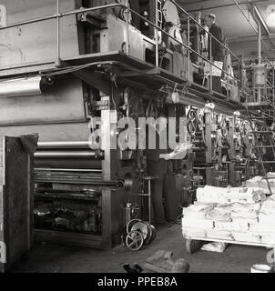 1950er Jahre, ein Manager steht unter dem riesigen Druckmaschinen mit einem Betreiber oben, während Sie die Zeitschriften, die bei HWV Drucker, Aylesbury, Bucks, England, UK gedruckt wurden. 1963 Das Unternehmen würde die Britihs Drucken Corporation eine der größten Druckereien in Großbritannien, später Übernommen von Robert Maxwell. Stockfoto