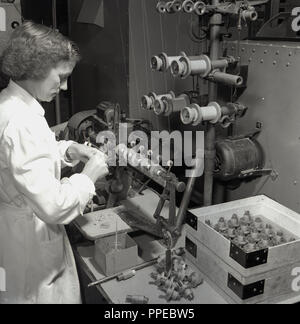 1950er Jahre, Arbeiterin Kontrolle der Teile für Bush Radio, einem führenden britischen Elektronik Hersteller von Radios und Fernsehgeräte in diesem Zeitalter. Stockfoto