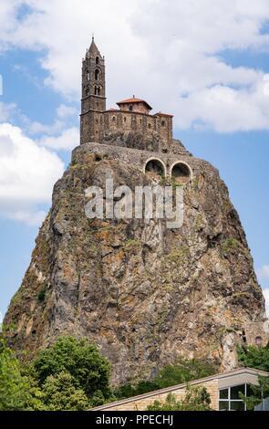 Hoch oben auf einem Hügel Basalt in der Stadt Le-Puy-en-Velay liegt die Kirche von Saint-Michel d'Aiguilhe (St. Michael auf der Nadel). Der Ort ist Ausgangspunkt der Französischen Jakobsweg. (29. Juni 2018) | Verwendung weltweit Stockfoto