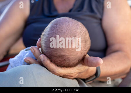 Wheat Ridge, Colorado - hält eine Frau an der Spitze eines schlafenden Säugling. Stockfoto