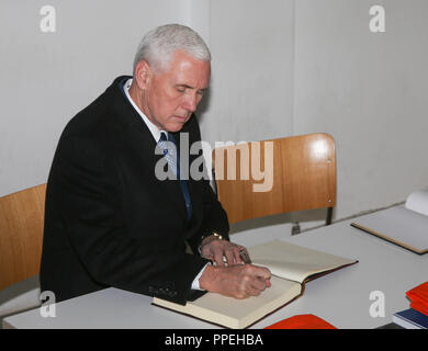 Die US-Vizepräsident, Mike Pence, Zeichen das Gästebuch des Museums bei seinem Besuch in der KZ-Gedenkstätte Dachau. Stockfoto