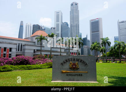 Die wunderschönen Parlamentsgebäude Gebäude mit die Wolkenkratzer des Financial District mit Lila Bougainvillea Blumen Hüllblätter in Singapur Asien Stockfoto