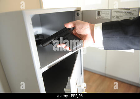 Vor einer Sitzung im Büro "interne Untersuchungen" im Bayerischen Landeskriminalamt (LKA) in Ridlerstrasse Beamten müssen von Hand ihre Waffe. Stockfoto